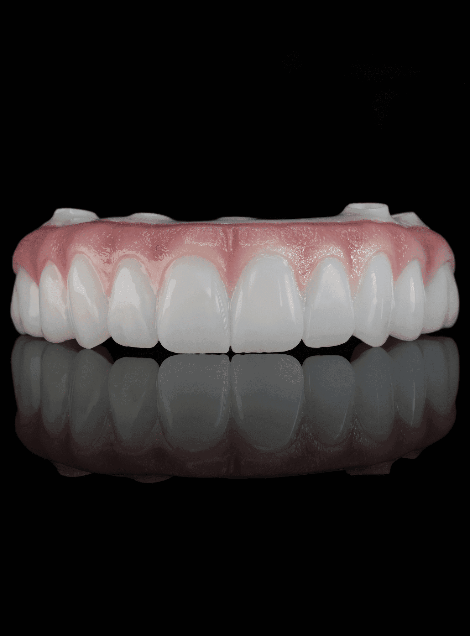 A monolithic zirconia All-on-X arch, stained and glazed, photographed on the bench